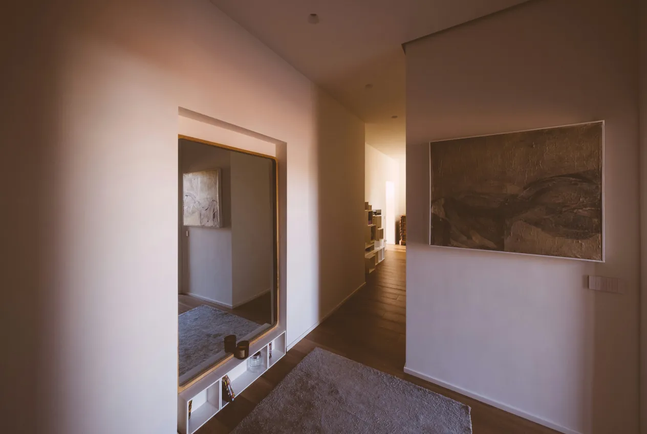 Avant : entrée d'appartement sombre, murs ternes et dominante orangée, tableau peu lisible