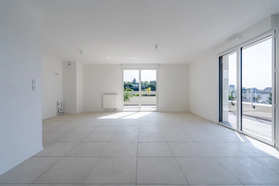 Séjour vide ouvert sur une terrasse, avant staging virtuel